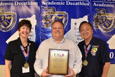 Coach Janet Bengtson, LMCHS Principal Charles Gent, and Coach Allen Tong proudly display the team's first place award at the United States Academic Decathlon held in Frisco, Texas.